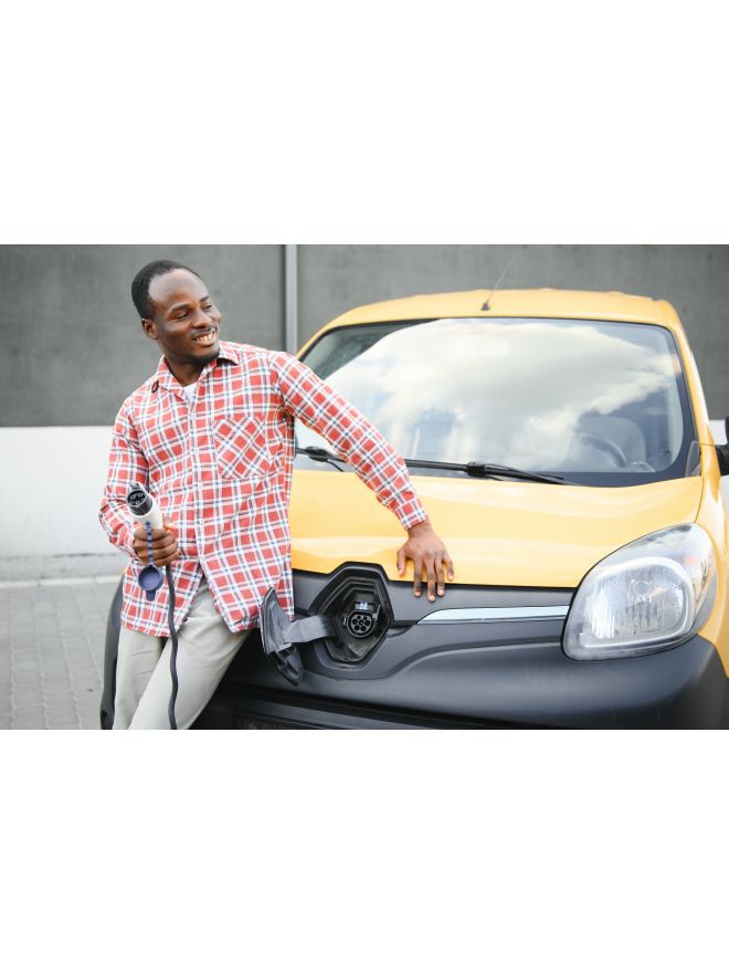 african-american-man-stands-electric-delivery-vans-electric-vehicle-charging-station.jpg